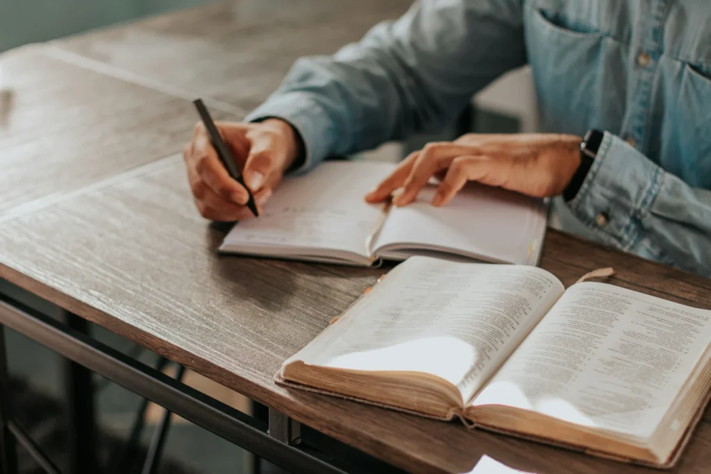 Person studying the bible and writing life lessons