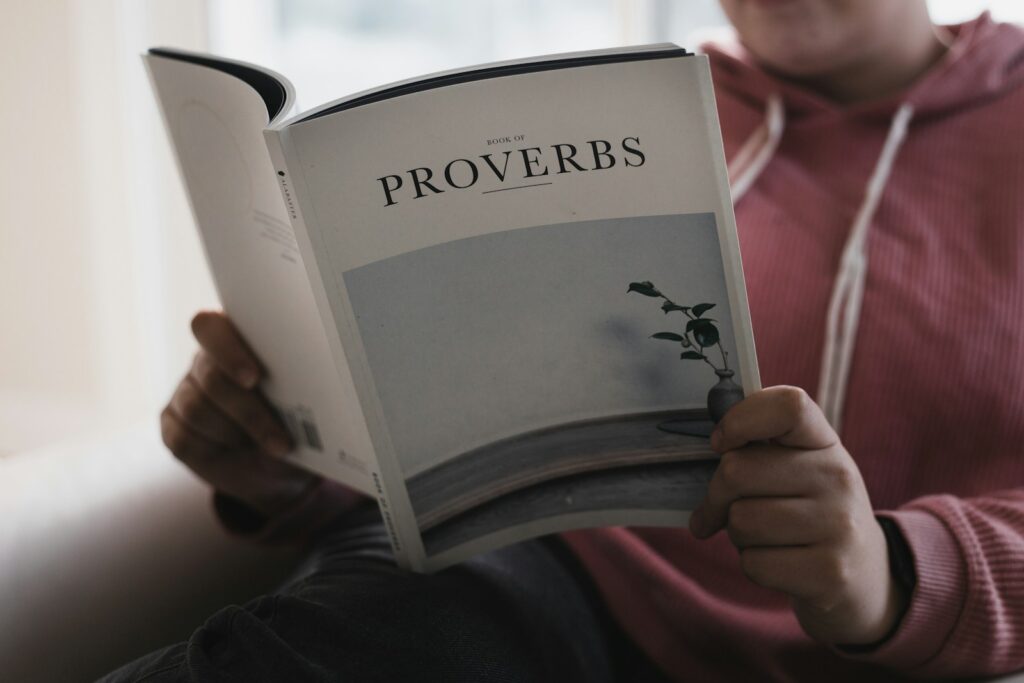 person holding reading the book of proverbs