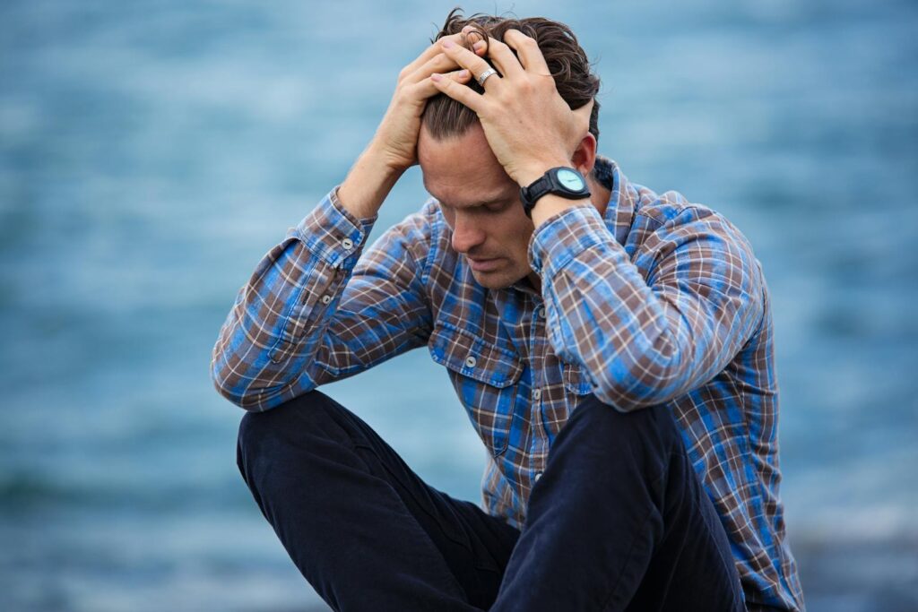 Church hurts: A hurt Man in Blue and Brown Plaid Dress Shirt Touching His Hair