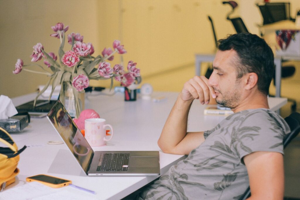 man in gray crew neck t-shirt using macbook pro