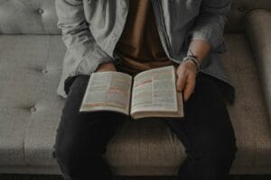 Blog person in gray denim jacket reading book