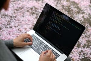 Blog person using macbook pro on pink and white floral textile