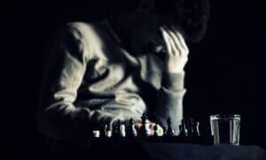 Blog a man sitting at a table with a chess board