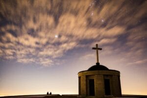 Blog silhouette of brick cathedral with cross finial under blue sky