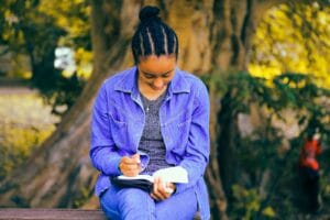 Blog selective focus photography of woman reading book while sitting at bench