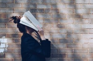 Blog woman covering her face with white book