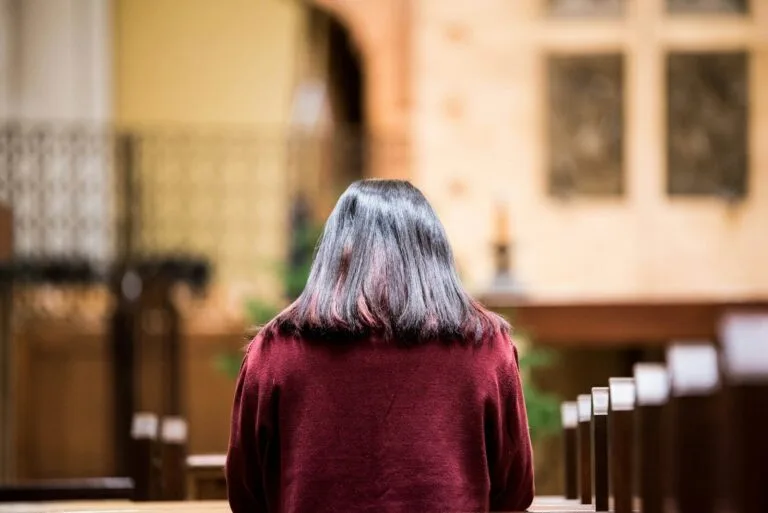 a woman with grey hair sitting in a church