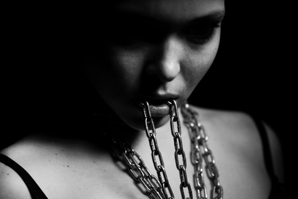 Human Trafficking: Everyday choices That Fuels Modern Slavery. grayscale photo of woman with chain