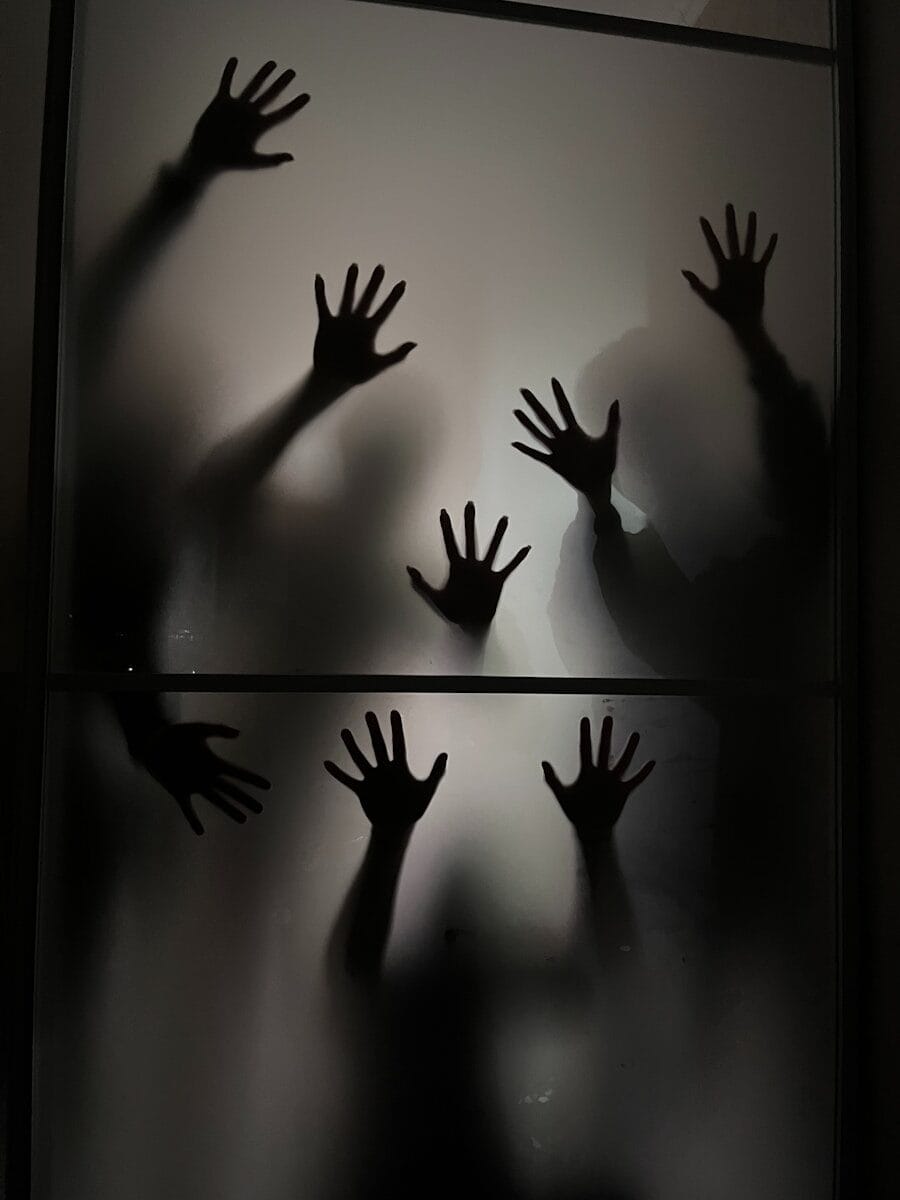 The shadow of a person's hands on a glass door